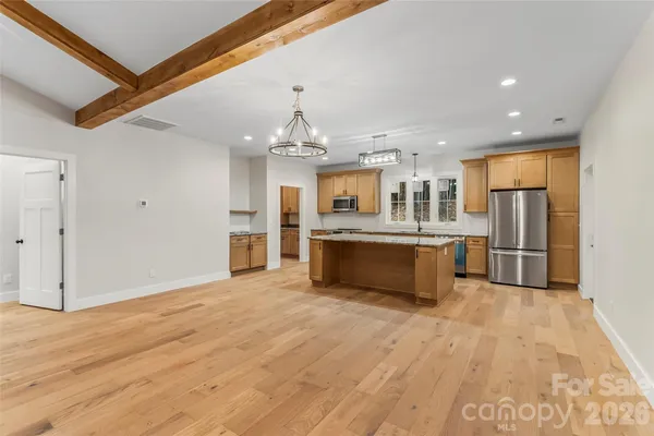 a large kitchen with stainless steel appliances kitchen island granite countertop a stove and a refrigerator