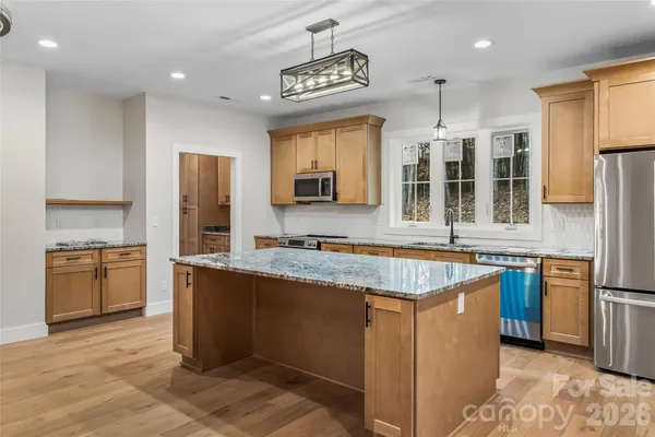a kitchen with stainless steel appliances granite countertop a sink stove and refrigerator