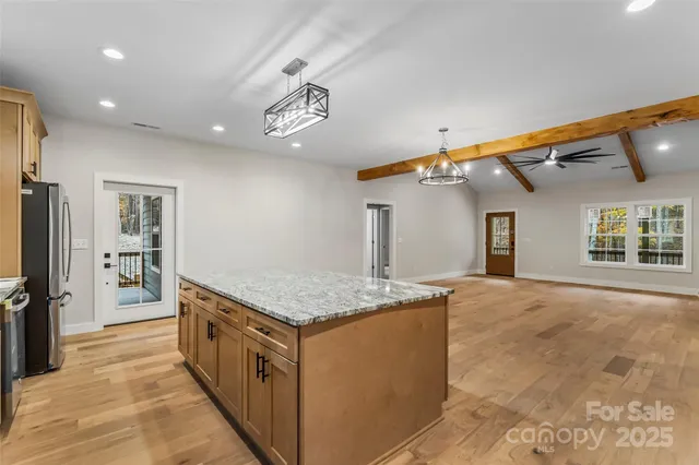 a kitchen with stainless steel appliances granite countertop a sink and a refrigerator