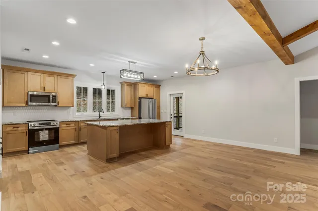 a large kitchen with stainless steel appliances granite countertop a stove and a refrigerator