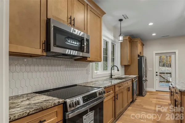 a kitchen with stainless steel appliances granite countertop a stove and a sink