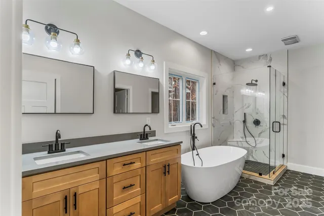 a bathroom with a granite countertop sink mirror bathtub and toilet