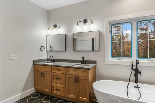 a bathroom with a granite countertop sink mirror and bathtub
