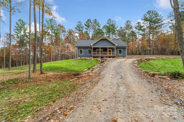 a front view of a house with a yard and trees