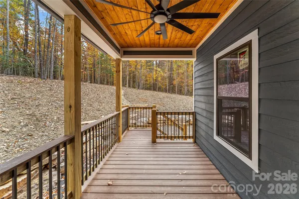 a view of a balcony with wooden floor and iron fence