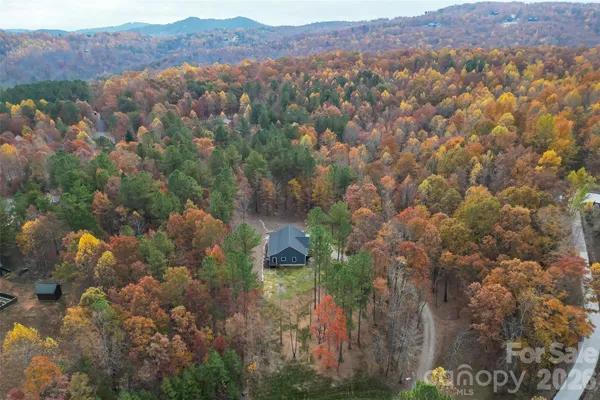 an aerial view of house with yard and mountain view in back