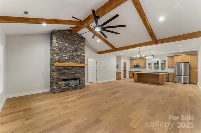 a view of an empty room with a fireplace and a fan