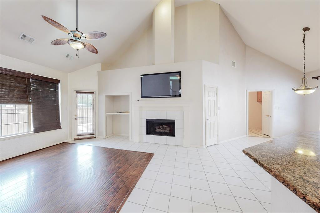 119 Parkhurst Lane Allen, TX 75013 - Photo 5 of 24 a view of a livingroom with a fireplace a ceiling fan and windows