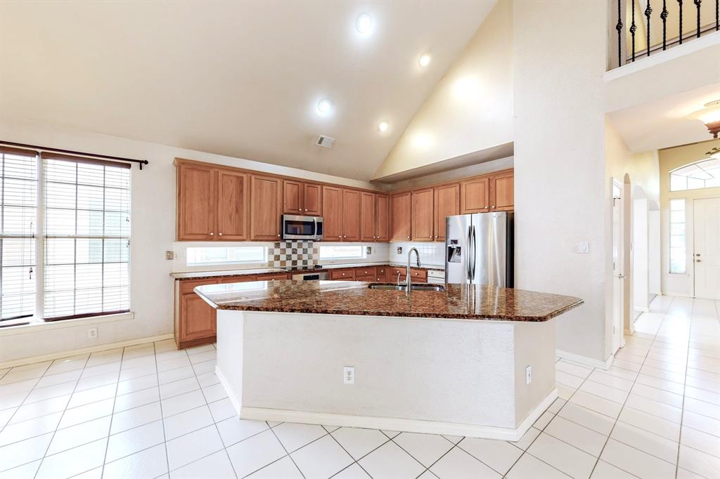 119 Parkhurst Lane Allen, TX 75013 - Photo 6 of 24 a kitchen with stainless steel appliances granite countertop a sink and a refrigerator