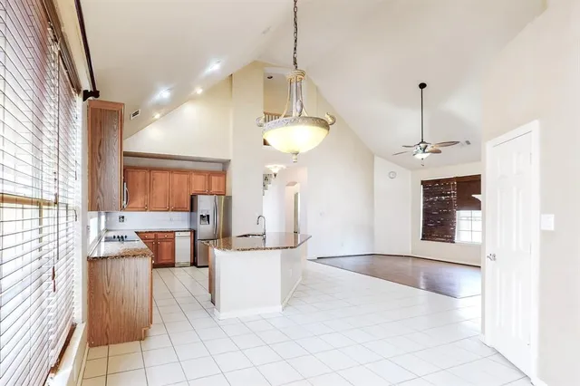 a kitchen with kitchen island a counter top space a sink stainless steel appliances and cabinets