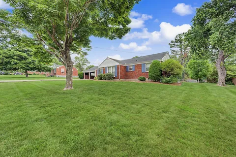 a backyard of a house with lots of green space and fountain