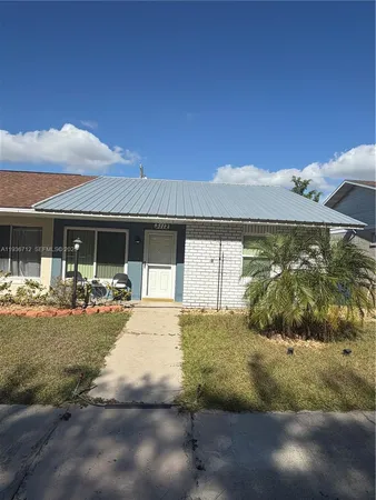 a view of house with backyard and outdoor seating