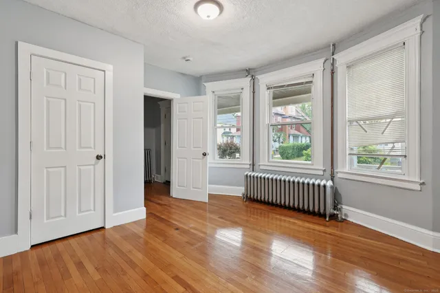 an empty room with wooden floor and windows
