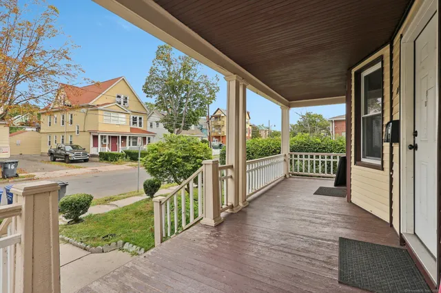 a view of a house with wooden fence next to a yard