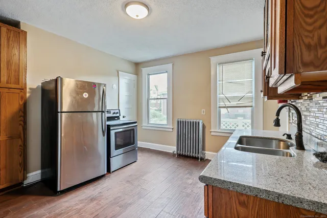 a kitchen with granite countertop a refrigerator and a sink