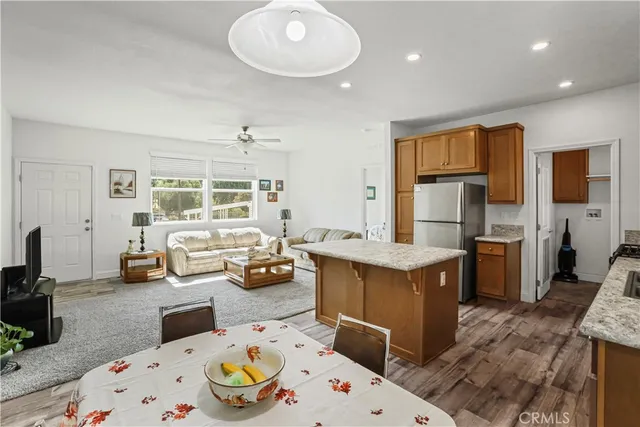 a kitchen with stainless steel appliances granite countertop a kitchen island a stove a sink and a microwave