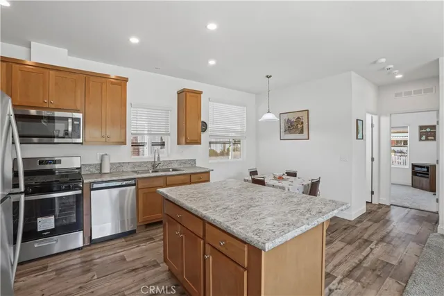 a kitchen with stainless steel appliances granite countertop a sink refrigerator and cabinets
