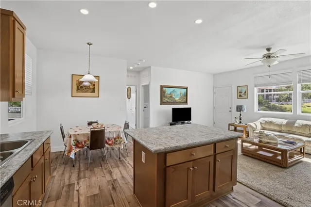 a kitchen with stainless steel appliances granite countertop a kitchen island hardwood floor sink stove and refrigerator