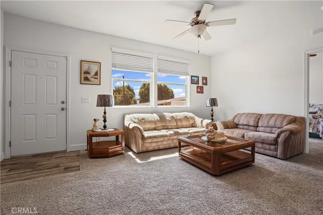 a living room with furniture kitchen view and a chandelier