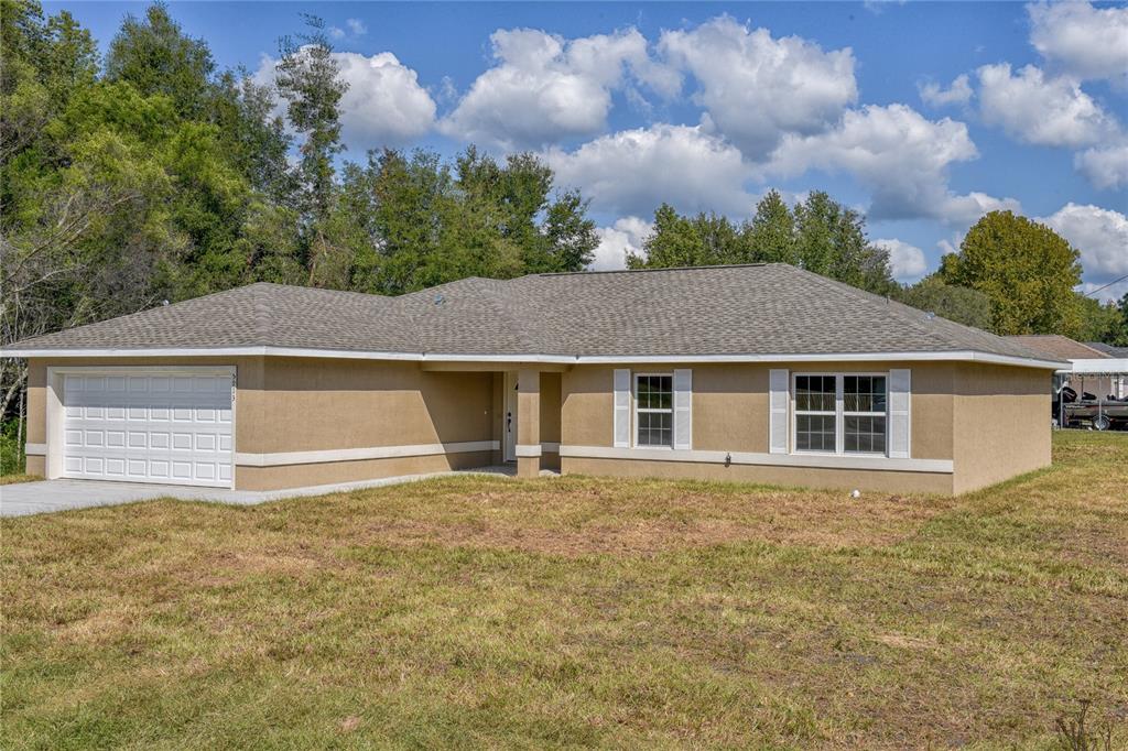 3039 Southwest Viburnum Road Dunnellon, FL 34431 - Photo 1 of 1 a front view of house with yard and trees in the background