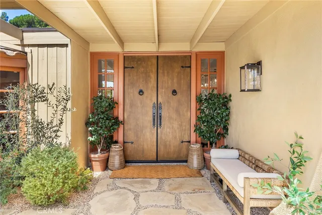 a living room with furniture a flat screen tv and floor to ceiling windows