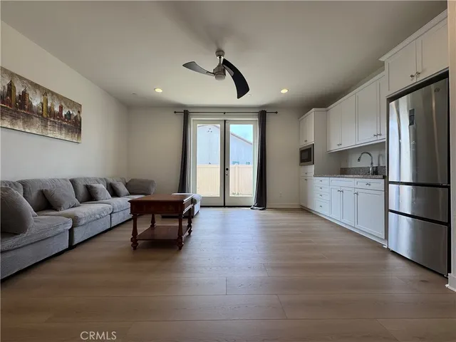 a living room with furniture and a refrigerator