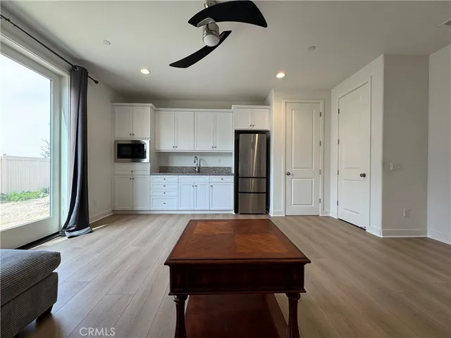 a kitchen with stainless steel appliances granite countertop a refrigerator a stove and a wooden floors