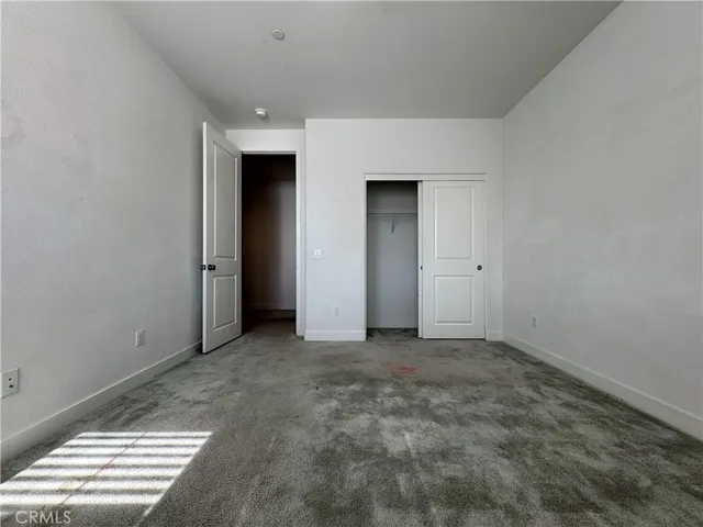an empty room with windows and closet