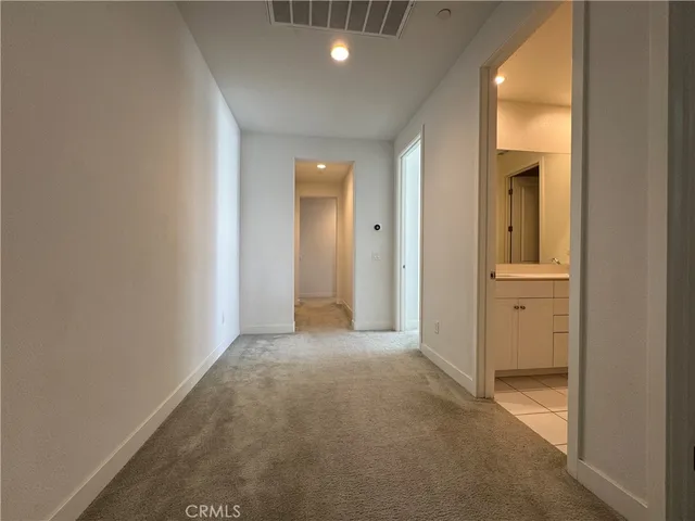 a view of a hallway with closet and wooden floor