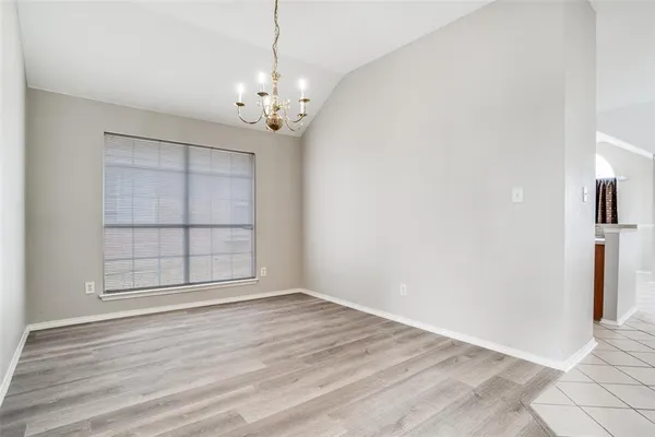 an empty room with wooden floor and window