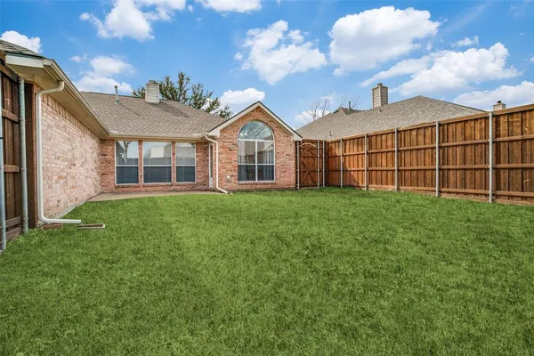 a view of a house with a big yard and large tree