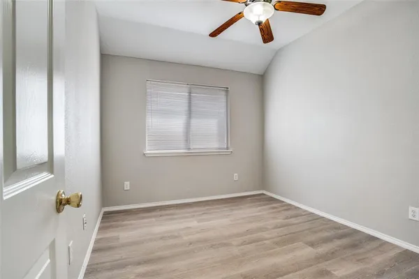 an empty room with a window and wooden floor