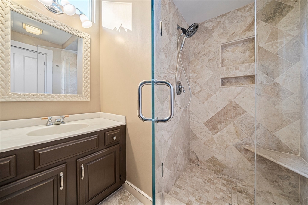 1032 Washington Street Canton, MA 02021 - Photo 31 of 42 a bathroom with a granite countertop sink a shower and a mirror
