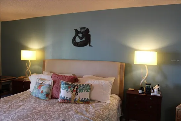 a bed sitting in a bedroom and chandelier