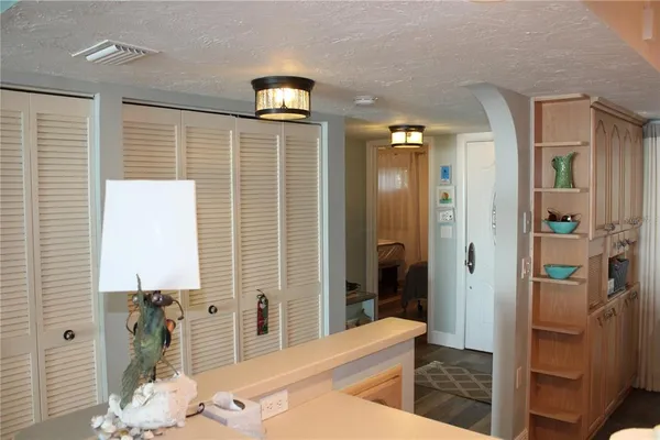 a bedroom with a bed and a lamp on dresser