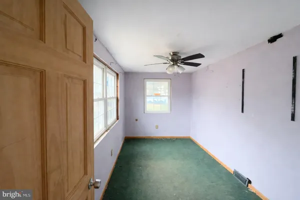 a view of a room with a ceiling fan and window