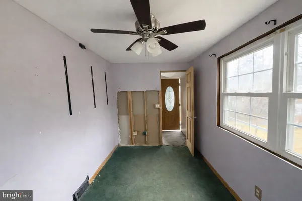 a view of a livingroom with a ceiling fan and window