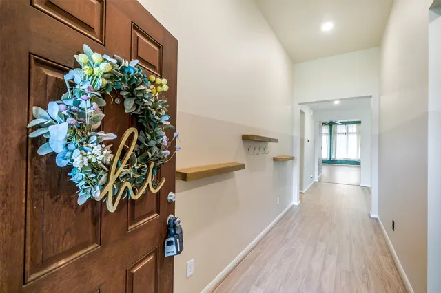 a view of a hallway with wooden floor and a potted plant