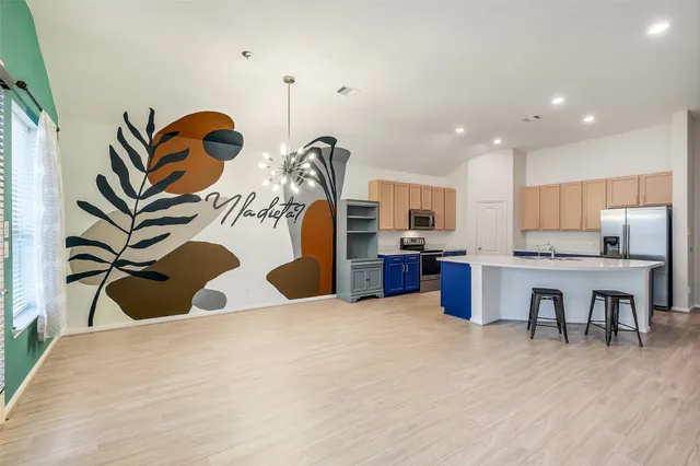 a view of kitchen with stainless steel appliances cabinets and wooden floor