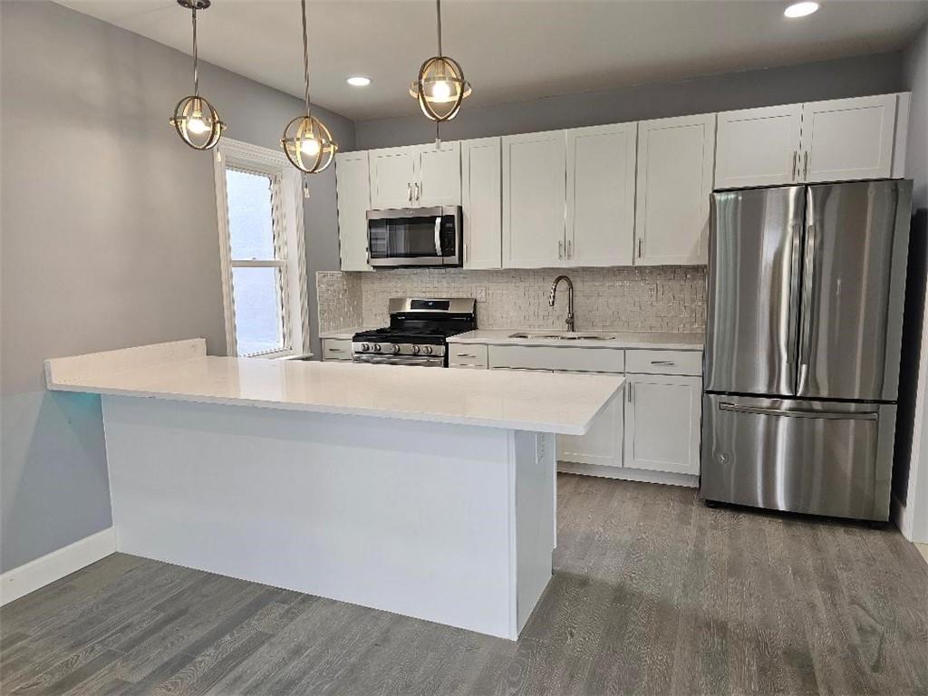 477 Connecticut Avenue Rochester, PA 15074 - Photo 4 of 17 a kitchen with stainless steel appliances a refrigerator a stove a sink and white cabinets