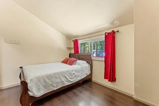 a bedroom with a bed and a wooden floor