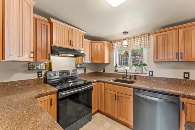 a kitchen with stainless steel appliances granite countertop a sink stove and cabinets