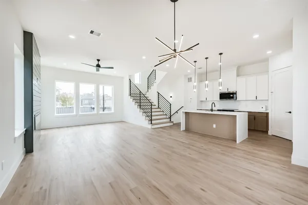 a large kitchen with granite countertop a large counter top a sink stainless steel appliances and cabinets