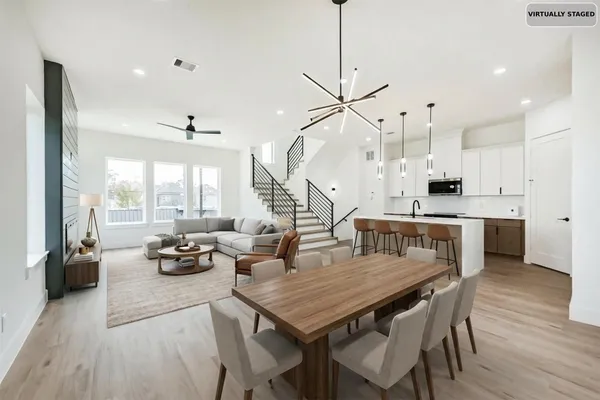 a open kitchen with kitchen island a stove a sink a center island a refrigerator and a wooden floor