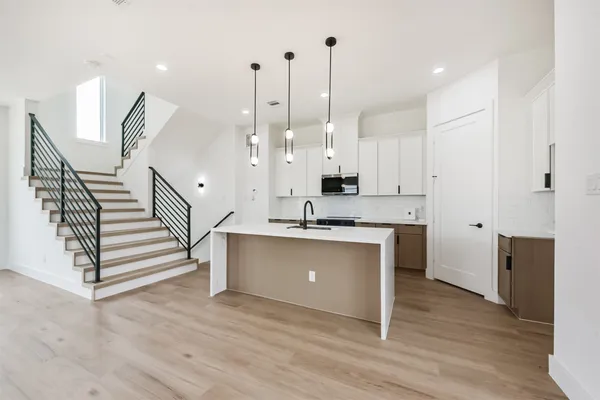 a dining room with furniture a chandelier and wooden floor