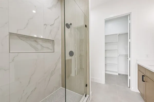 a bathroom with a shower and a glass door