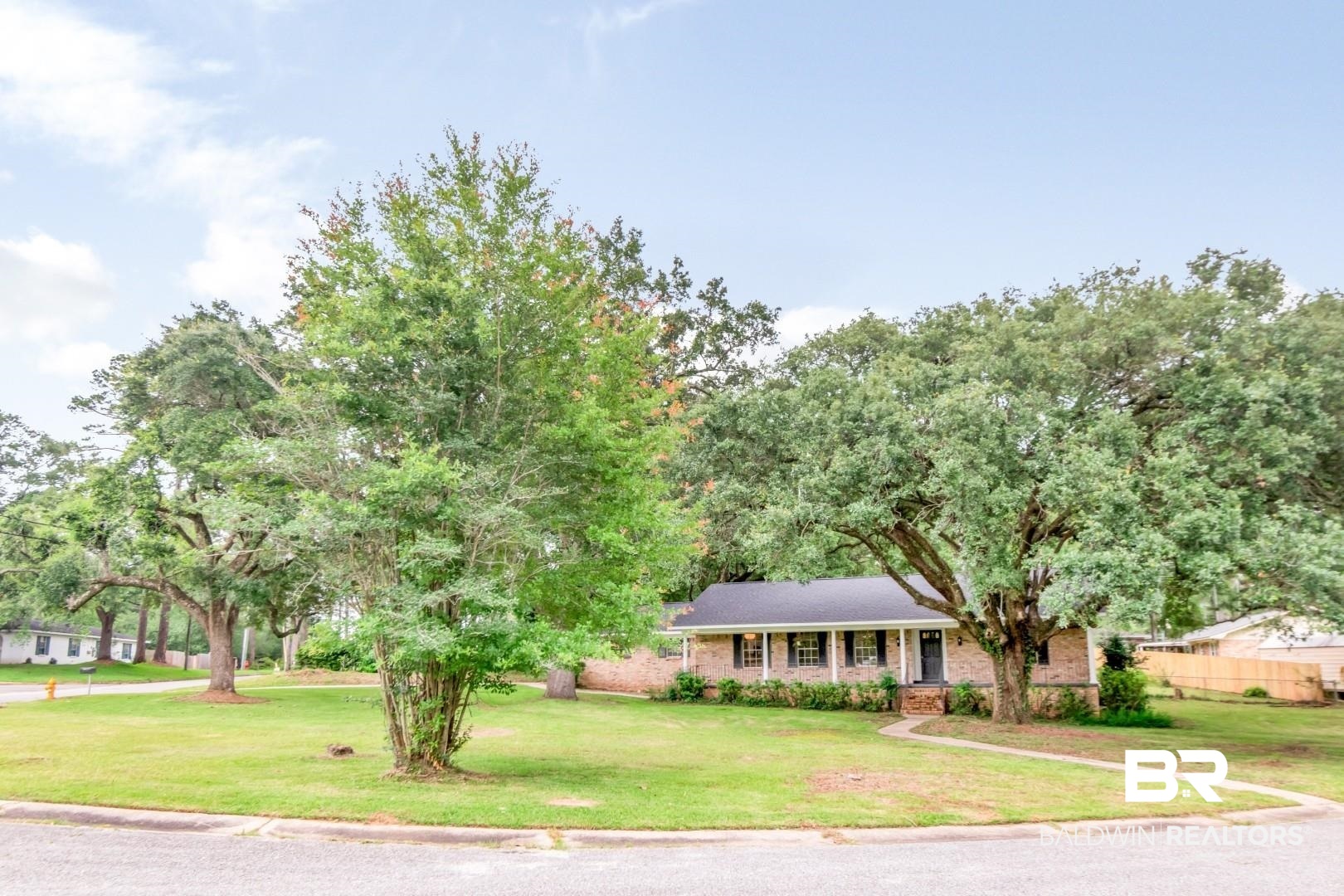 5217 Perin Road Mobile, AL 36693 - Photo 41 of 45 Brick facade home with a dark shingle roof and a covered front porch featuring white columns