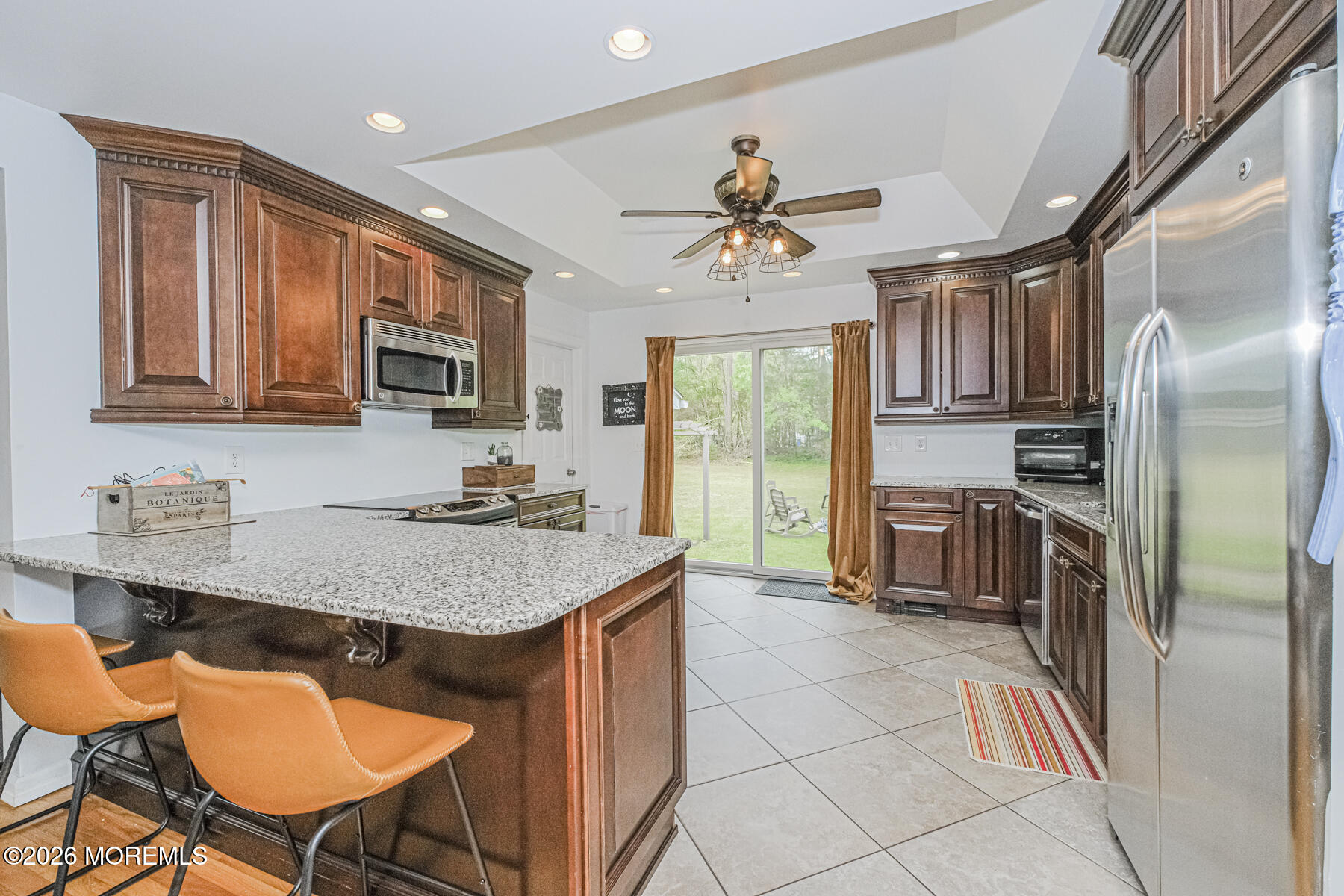 5 Riccis Drive Jackson, NJ 08527 - Photo 13 of 32 a kitchen with stainless steel appliances granite countertop a stove a refrigerator a sink a dining table and chairs