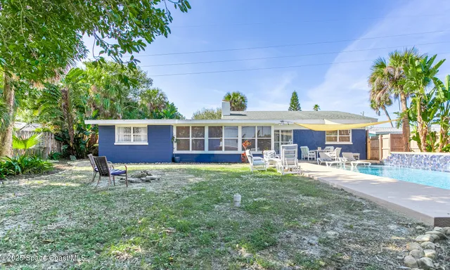 an aerial view of ocean and residential houses with outdoor space