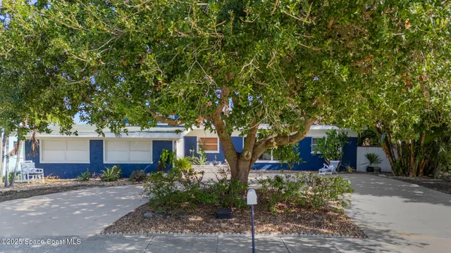 a front view of a house with a yard and tree s